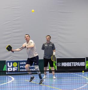 Ukrainian combat veteran athletes Oleksandr Dehtiar and Mykola Zarytskyi playing pickleball together on an indoor court at the First Ukrainian Veterans Pickleball Championship in Kyiv, 2026.