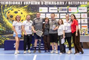 Ukrainian combat veteran athletes Oleksandr Dehtiar and Mykola Zarytskyi on stage receiving the Fantastic Team award at the First Ukrainian Veterans Pickleball Championship in Kyiv, 2026, with family and officials.
