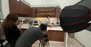 Two ALIQ Studio photographers working with professional lighting during a beverage content shoot in Kuala Lumpur.