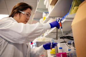 Female scientist in a white lab coate working with a sample