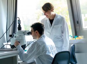 Two scientists in white lab coats working in a laboratory