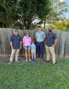 R. Short Roofing representatives standing outdoors with the Free Roof Giveaway recipient and her child in Magnolia, Delaware.
