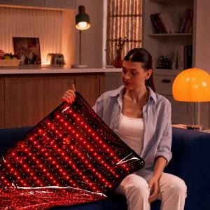 Consumer using a red light therapy device at home as part of a personal wellness and self-care routine.