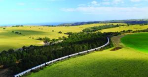 Aerial view of the Rovos Rail Pride of Africa train curving through green hills in South Africa