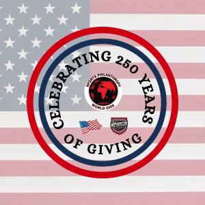 SPW2026 Flag celebrating 250 years of giving in the United States features a US flag bckground with a circle around the logos for SPW2026, Sports Philanthropy Network and the US flag