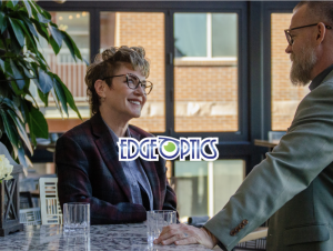 Fashionable woman in cat eye glasses smiling at a well dressed man