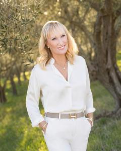 Celeste White standing in a grove of olives
