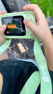 Child using a mint-green Dr.Look Ai Learning Camera to identify a monstera plant.
