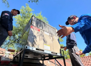 Mechanical Air HVAC technicians working together on a rooftop heating and cooling unit installation in California.