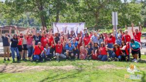 Jay Nolan staff posing for a group picture at a park. Many are wearing red.