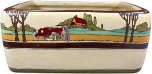Lovely Roseville pottery planter in the Tourist pattern showing an early automobile scene of a couple tending to a flat tire in a colorful country setting. Estimate: $1,000-$2,000