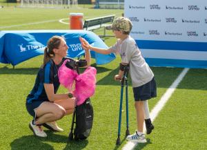 8-year-old Ryan Brooks receiving equipment from a female