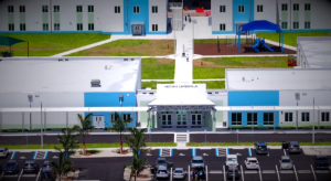 Aerial view of Hector A. Cafferata Jr. K-8 School's main entrance, walkways, playground, and parking area.