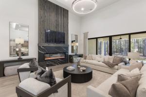 Great room inside Design Tech Homes' award-winning showcase home in The Estates of Texas Grand Ranch, featuring vaulted ceilings, a modern fireplace, large windows, and open-concept living spaces.
