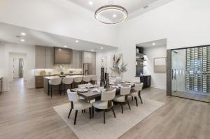 Open-concept living area inside Design Tech Homes' award-winning showcase home in The Estates of Texas Grand Ranch, featuring a gourmet kitchen, dining area, spacious great room, and contemporary custom home design.