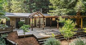Remodeled Redemption Canyon residence with a large wooden deck and pergola among Sonoma County redwoods.