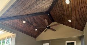 Vaulted stained wood ceiling and exposed beam on a covered patio addition at a Conroe, Texas home