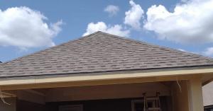 New architectural asphalt shingle roof on a covered patio addition under construction at a Conroe, Texas home