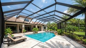 A pool area featuring a glass roof enclosure, surrounded by a patio for outdoor relaxation.