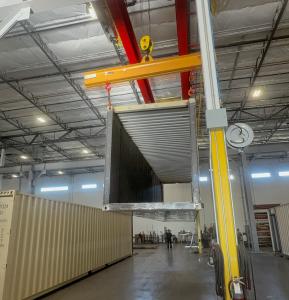 A bridge crane lifting a shooting range container.