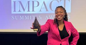 Monique Farmer, APR, displays one of her two awards at the Women of Impact Awards celebration in Chicago.