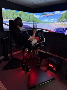 A driver experiences the DDX Precision simulator at the new Driven DynamiX showroom in Bellevue, Washington, where enthusiasts and track-day drivers can explore legendary cars and circuits through immersive motorsport simulation.
