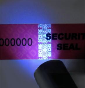 Close-up image of a tamper evident label with a light scanning for additional holographic and security elements.