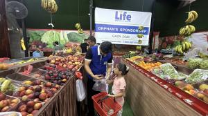 Photo of a sponsored orphan receiving essential food items from a Life for Relief and Development (LIFE) team member.