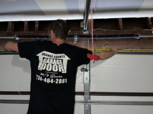 Orange County Garage Doors technician working on a residential garage door torsion spring system in Orange County, California