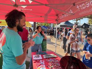 ArrowHeart Foundation and Arrowhead Credit Union participating at the National Night Out event in Fontana, CA. The crowd stopping by their table to spin the game wheel and win giveaways.