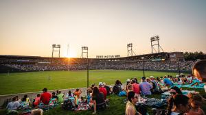 A wide view of Huntington Park in Columbus, Ohio, with fans seated around the field during a Columbus Clippers baseball game at sunset.