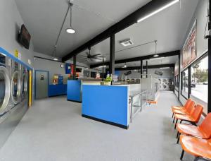 Interior of Sparkle Laundry Lounge in Burbank with commercial laundry machines, service counter and customer seating.