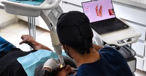 Dentist using digital dental imaging technology to examine a patient during a smile makeover procedure.