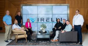 Members of the Virelli team gathered in front of a large Virelli logo display at the company’s Greenville headquarters.