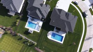 Aerial view of two custom inground pools in landscaped Overland Park, KS backyards, built by Hardscape Contractors