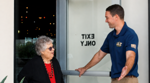 A SALT Plumbing, Air & Electric technician holds a door open for an older woman using a cane