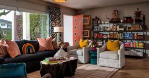 Eclectic living room by Blue Daze Designs with a coral door, sculptural furniture and colorful artistic accents.