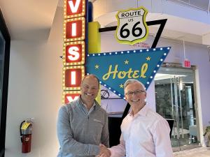 Matt Goche, CEO of Uniguest, and Sean Matthews, CEO at Visix shake hands on the acquisition.