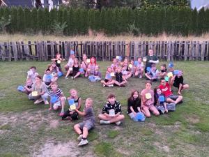 Children at Common Man for Ukraine's mental health retreat sit together in a heart shape.