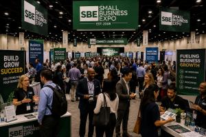 Crowded Small Business Expo trade show floor with entrepreneurs and business professionals networking among exhibitor booths.