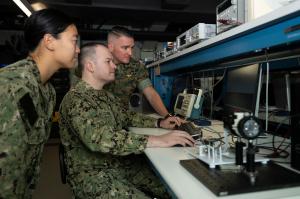 Members of the Terahertz Imaging Camera (TIC) team — U.S. Navy Ensign Yvonne Fu and Lt. Joshua McCowan and Marine Corps Lt. Col. Brian Neri, from left — review the technology’s concept of operations in the space systems lab.