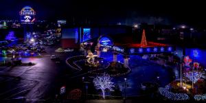 Aerial view of Seven Feathers Casino Resort's illuminated entrance with a lit eagle statue, red holiday tree and glowing archway, decorated by Christmas Decor.