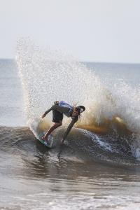 Timmy Gamboa skimboarding backside slash in Dewey Beach