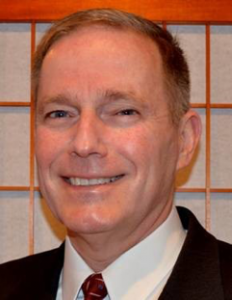 John Pross, PMP®, Distinguished Cheetah Alum Award for Inspiring Others, smiling for a professional picture wearing a suit and tie.