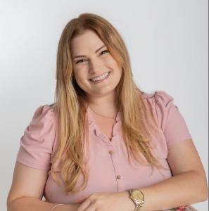 Gina Romero Author, Speaker, Podcaster, Television Host in pink with Welcome Home book