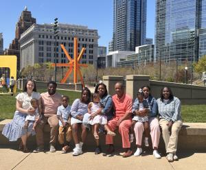 A multigenerational family gathered together outdoors with adults and children.