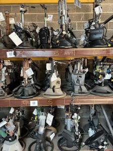 Rows of automotive steering columns with inventory tags arranged on shelving.