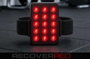 Small red light panel hybrid with strap for a wearable device on the gym floor.