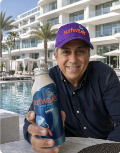 Serkan Barutcu, founder and CEO of Surfwater California, holding a Surfwater aluminum water bottle at a luxury California resort pool.