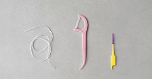 Overhead view of string floss, a floss pick, and a soft pick arranged side by side.